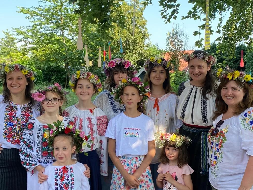 Fete și femei în costume populare, cu coronițe de flori, la o întâlnire Nepsis